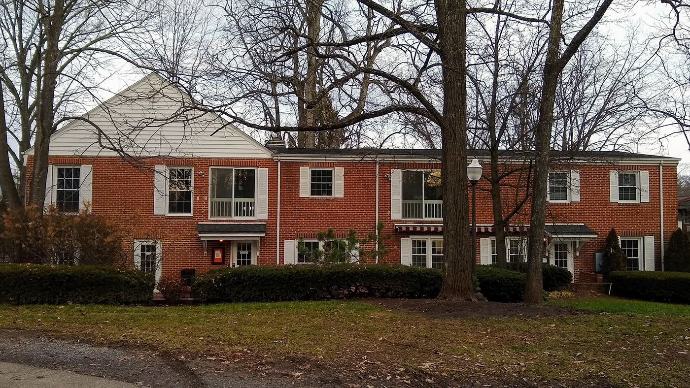 Rear view of 417 Clay St SW, a long brick house with trees in front of it.